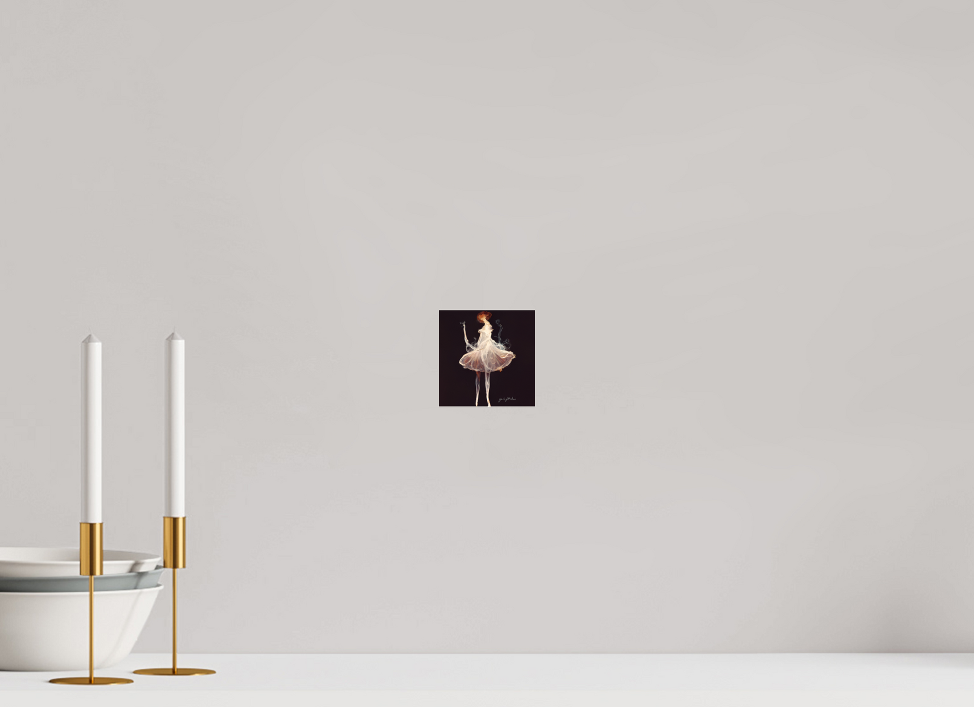 Wall art of a ballerina in a tutu on a plain wall with two white candles in gold holders.