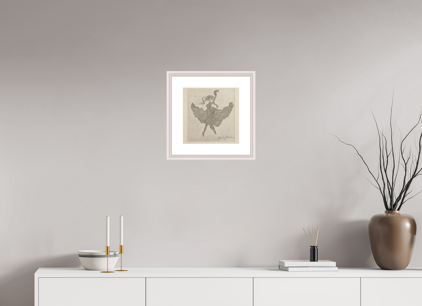 Framed artwork on a wall above a white cabinet with decorative items.